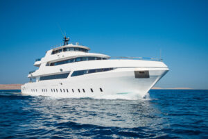 A luxury private motor yacht under way on tropical sea with bow wave