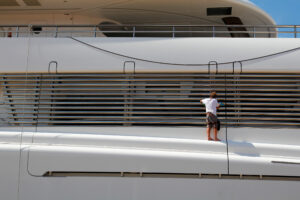 Luxury yacht moored on harbor, being cleaned