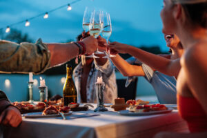 Friends raising glass to do a toast during dinner on a superyacht