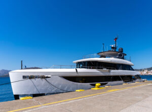 Luxury motor yacht being refueled the Marmaris marina pier on a clear sunny day, with a fuel tanker truck parked alongside the dock. Modern yacht design, waterfront marina view and harbor background.
