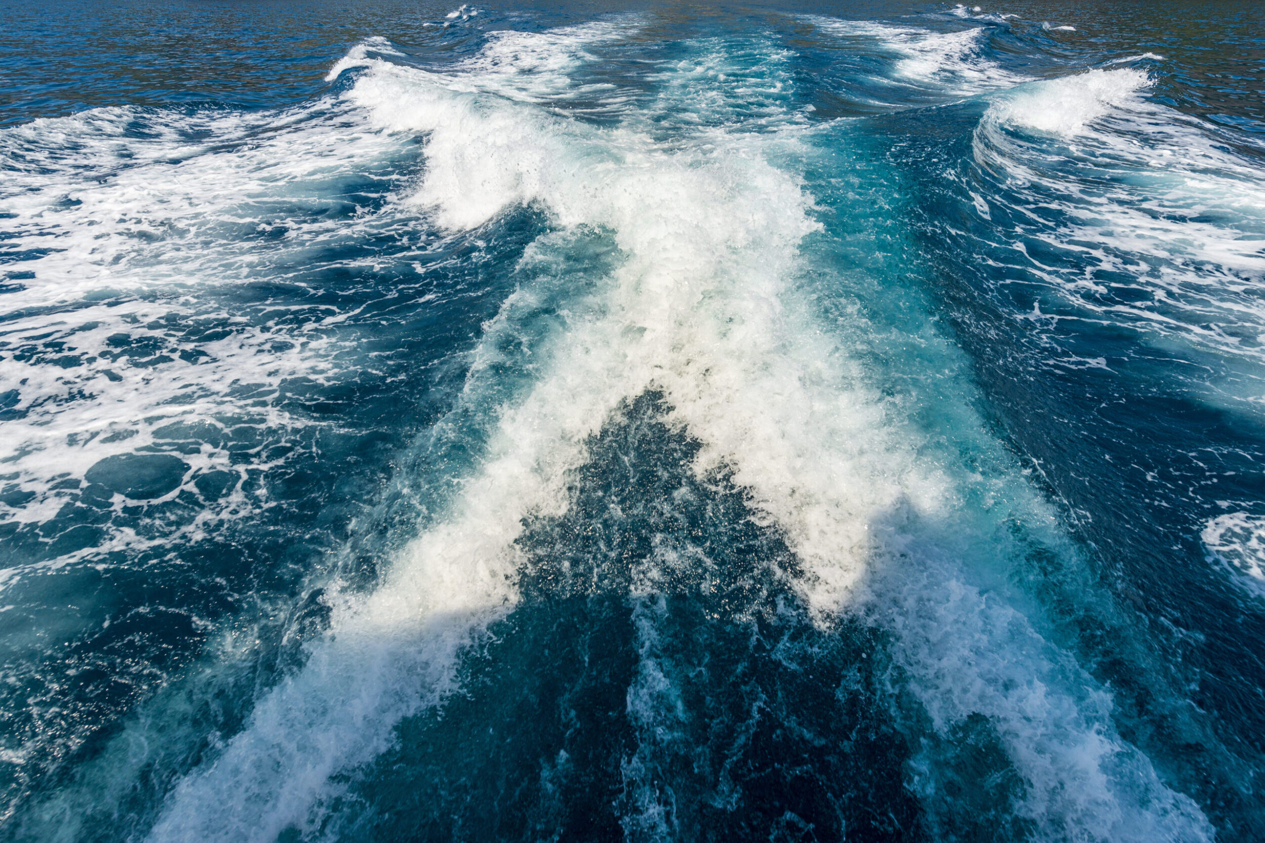 Close-up of the wake of a speedboat or ship, view from the stern of the boat, water, photography, full frame.