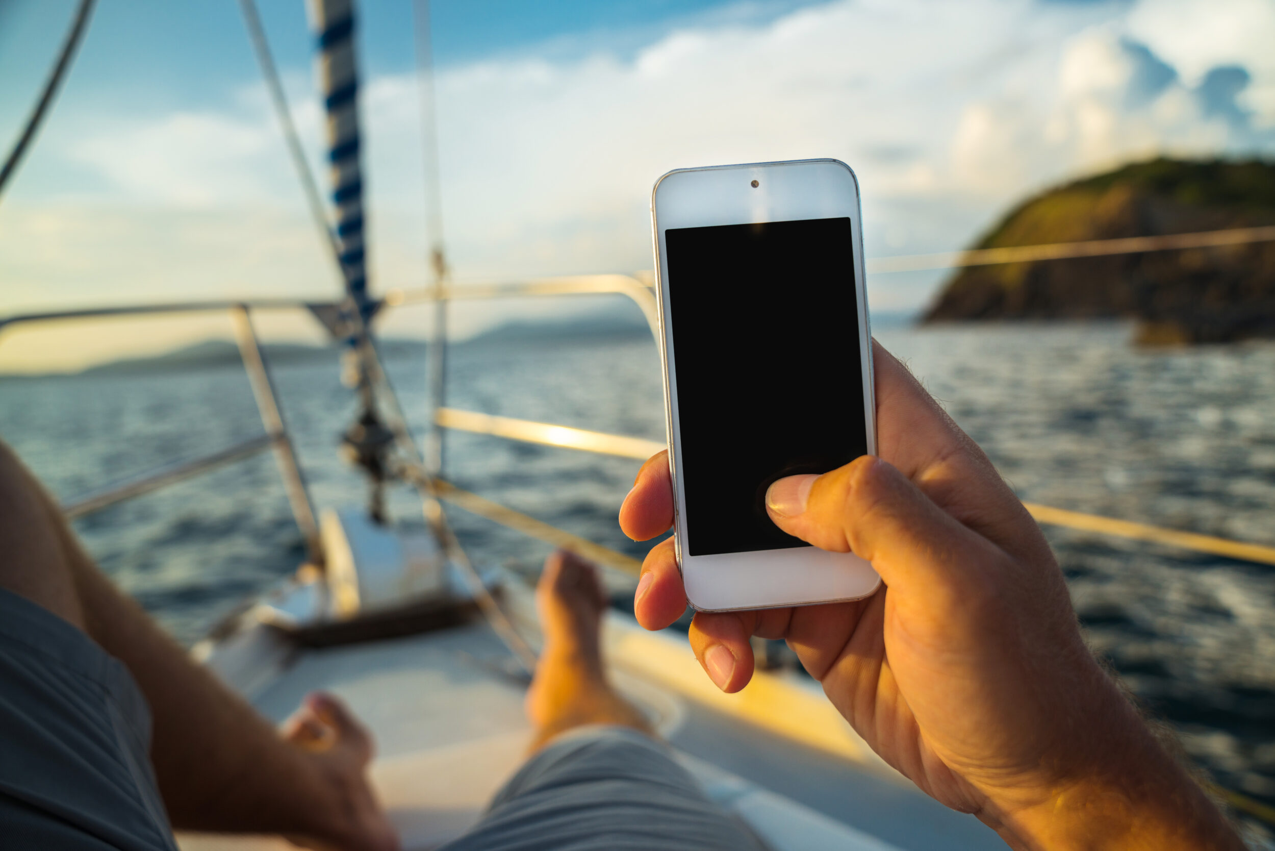 Crew member using phone on yacht