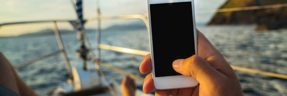 Crew member using phone on yacht