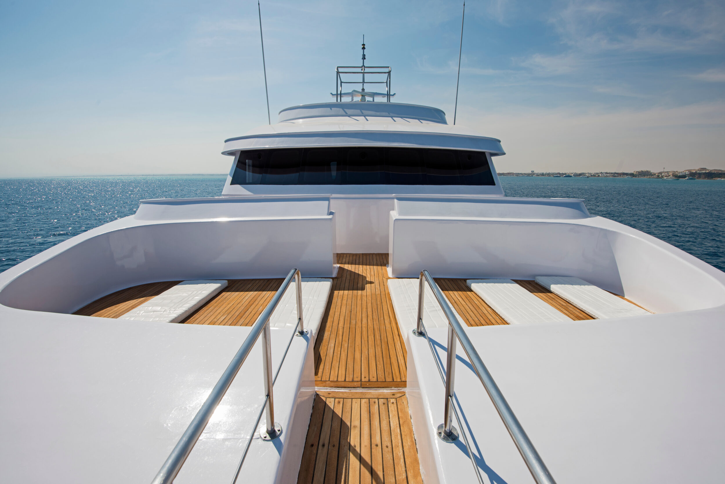 View over the bow of a large luxury motor yacht on tropical open ocean with bridge