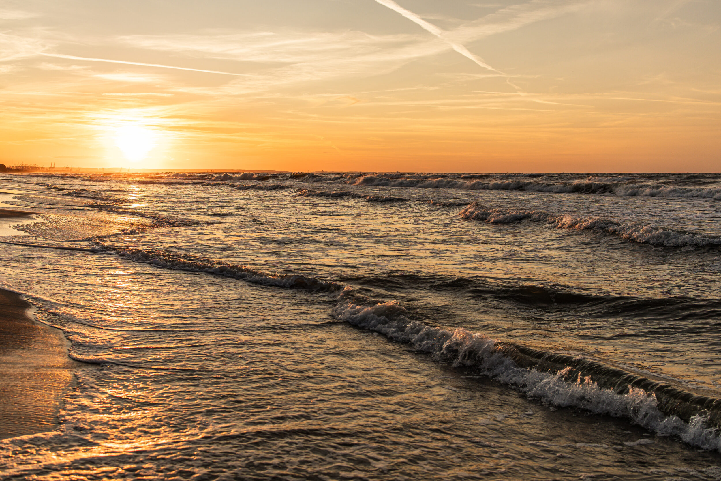 The sea at sunset, waves rolling onto the shore in Gdansk