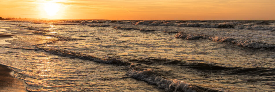 The sea at sunset, waves rolling onto the shore in Gdansk